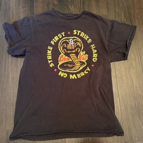 •COBRA KAI KARATE KID “STRIKE FIRST STRIKE HARD” UNISEX T-SHIRT - Picture 1 of 4